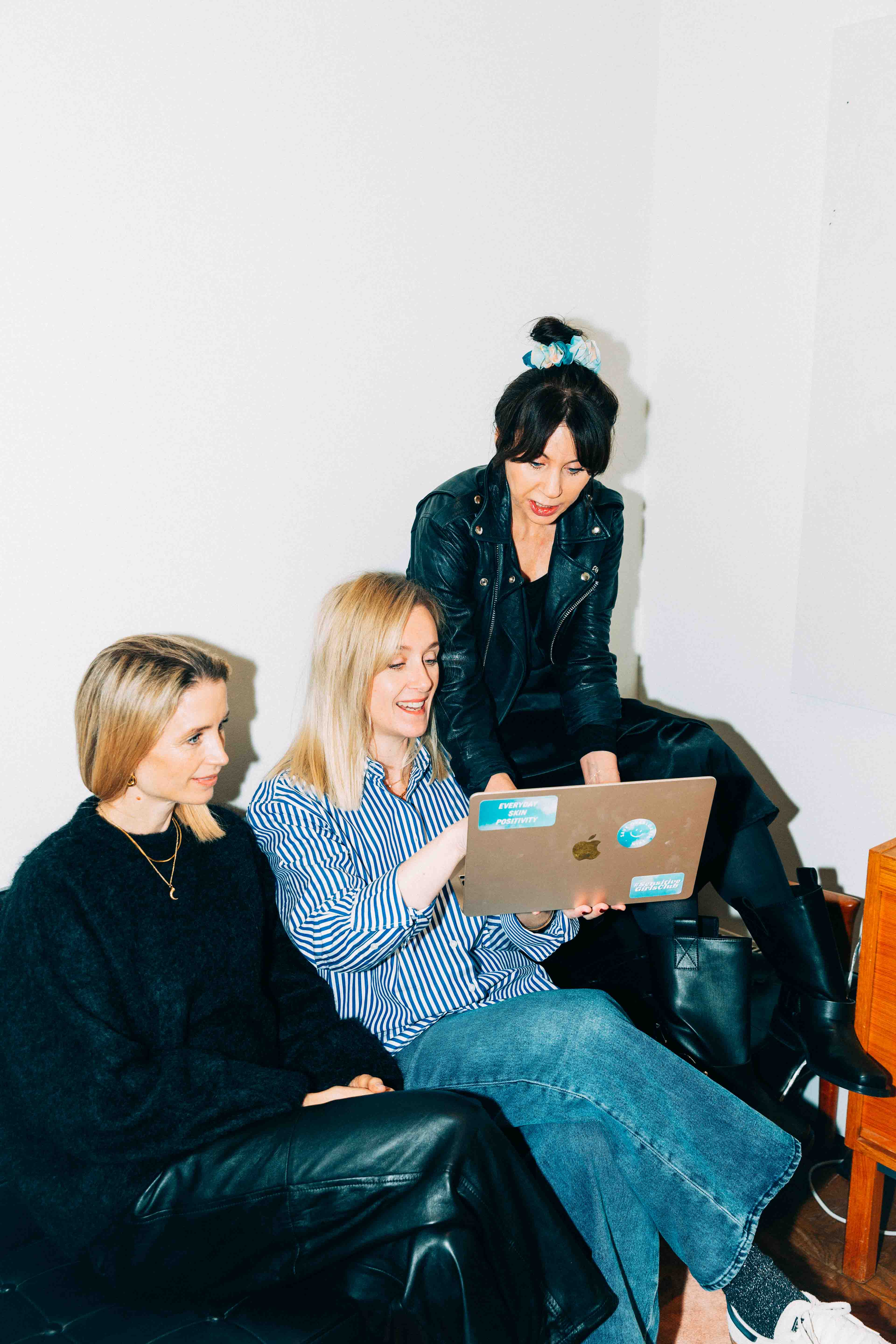 The founders of Common Clouds - Cajsa Horn, Helena Radelius and Maria Ahlgren are sat in a sofa looking at at computer screen.