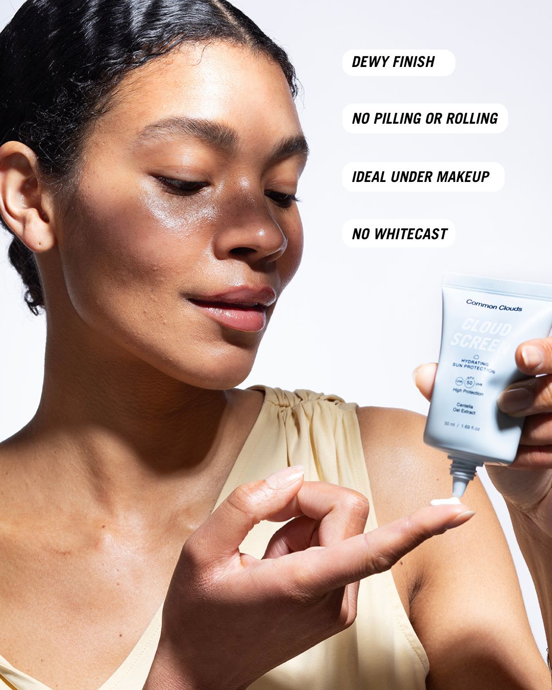 Woman applying sunscreen with Common Clouds Cloud Screen, showing dewy finish and ideal under makeup without whitecast