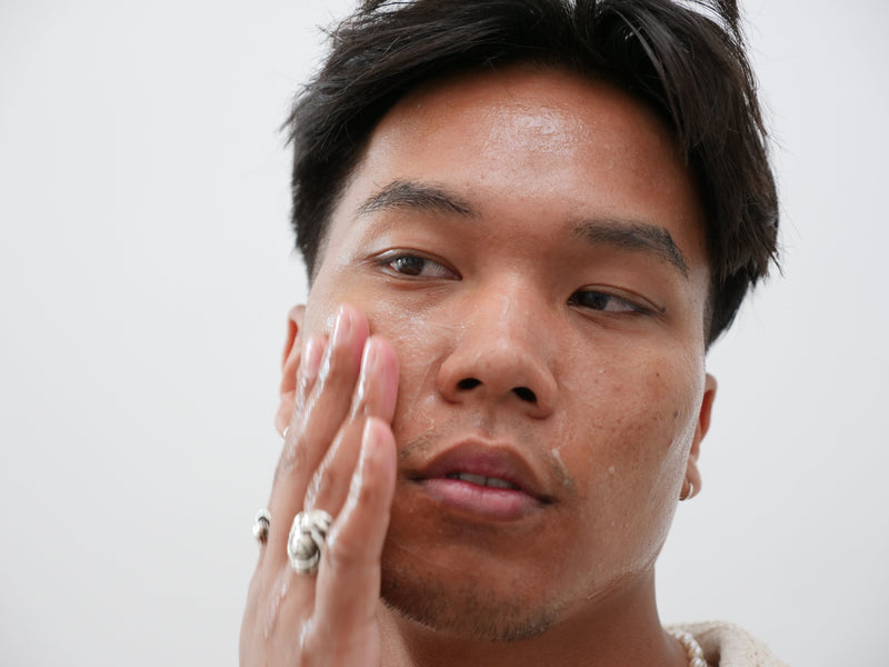 Boy doing skincare routine for oily skin. Ung man gör sin hudvårdsrutin anpassad för fet hud.