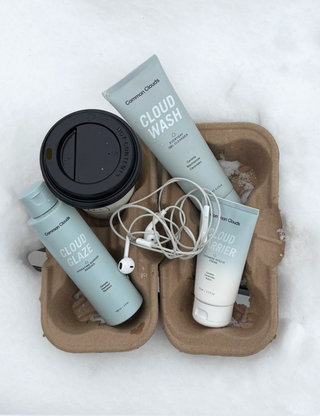 Cosmetic products including a bottle, tube, and container on a snowy background
