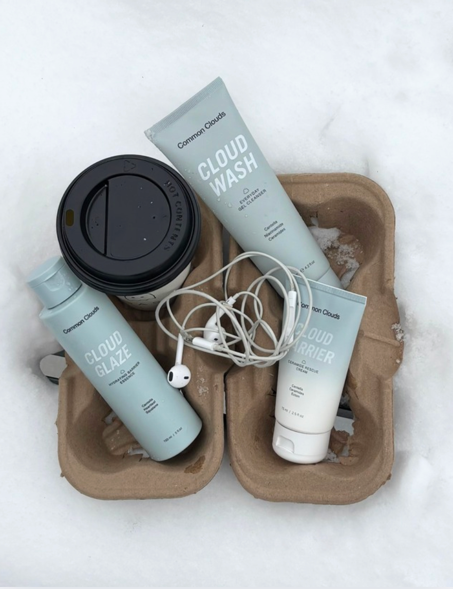 Cosmetic products including a bottle, tube, and container on a snowy background