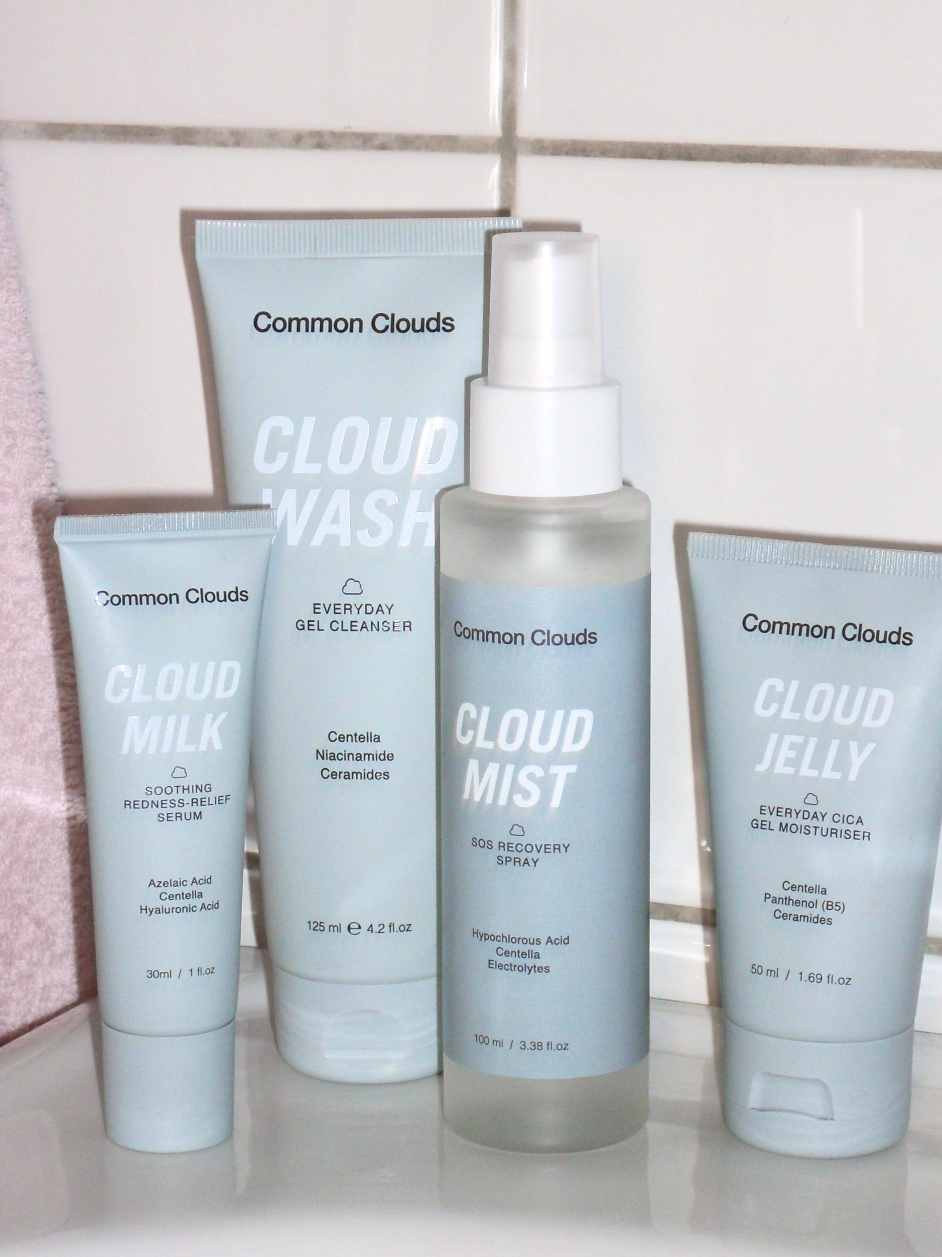 Set of Common Clouds skincare products including Cloud Wash, Cloud Milk, Cloud Mist, and Cloud Jelly on a white surface.