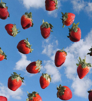 Fresh strawberries floating in the sky with white clouds.