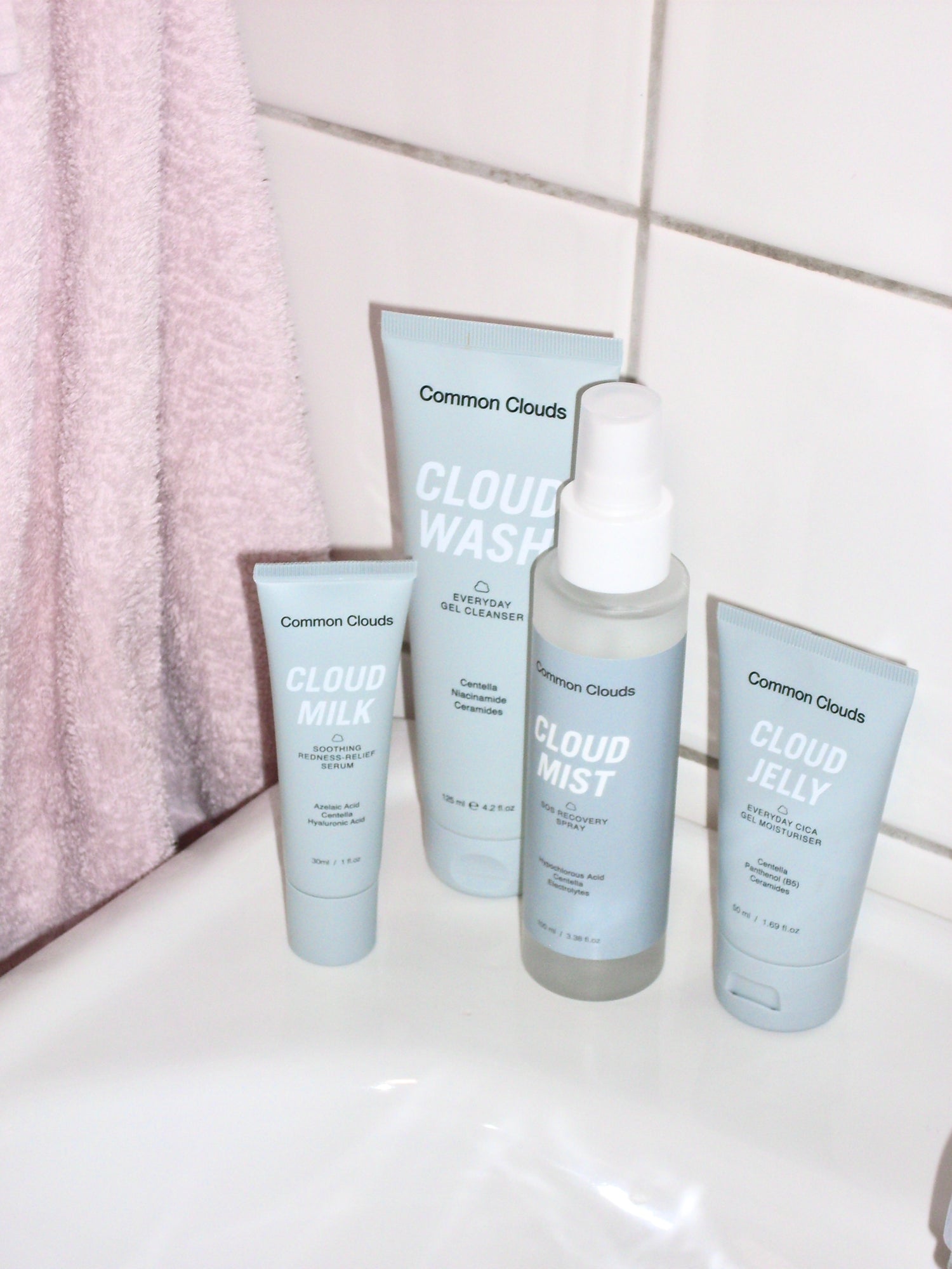Collection of Common Clouds skincare products on a bathroom counter.